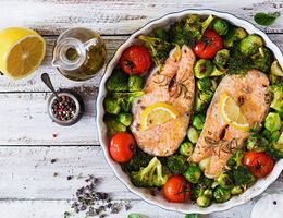 A baking dish with salmon and vegetables.